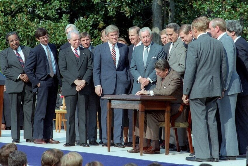 10/22/1986 President Reagan signing the Tax Reform Act of 1986 with members of Congress and White House staff present on the south lawn Dole Moynihan Kemp Byrd Regan Rostenkowski Thurmond Baker Gephardt Bush Duncan Kasten Long Rangel
